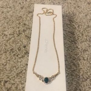 Gold necklace with emerald center stone